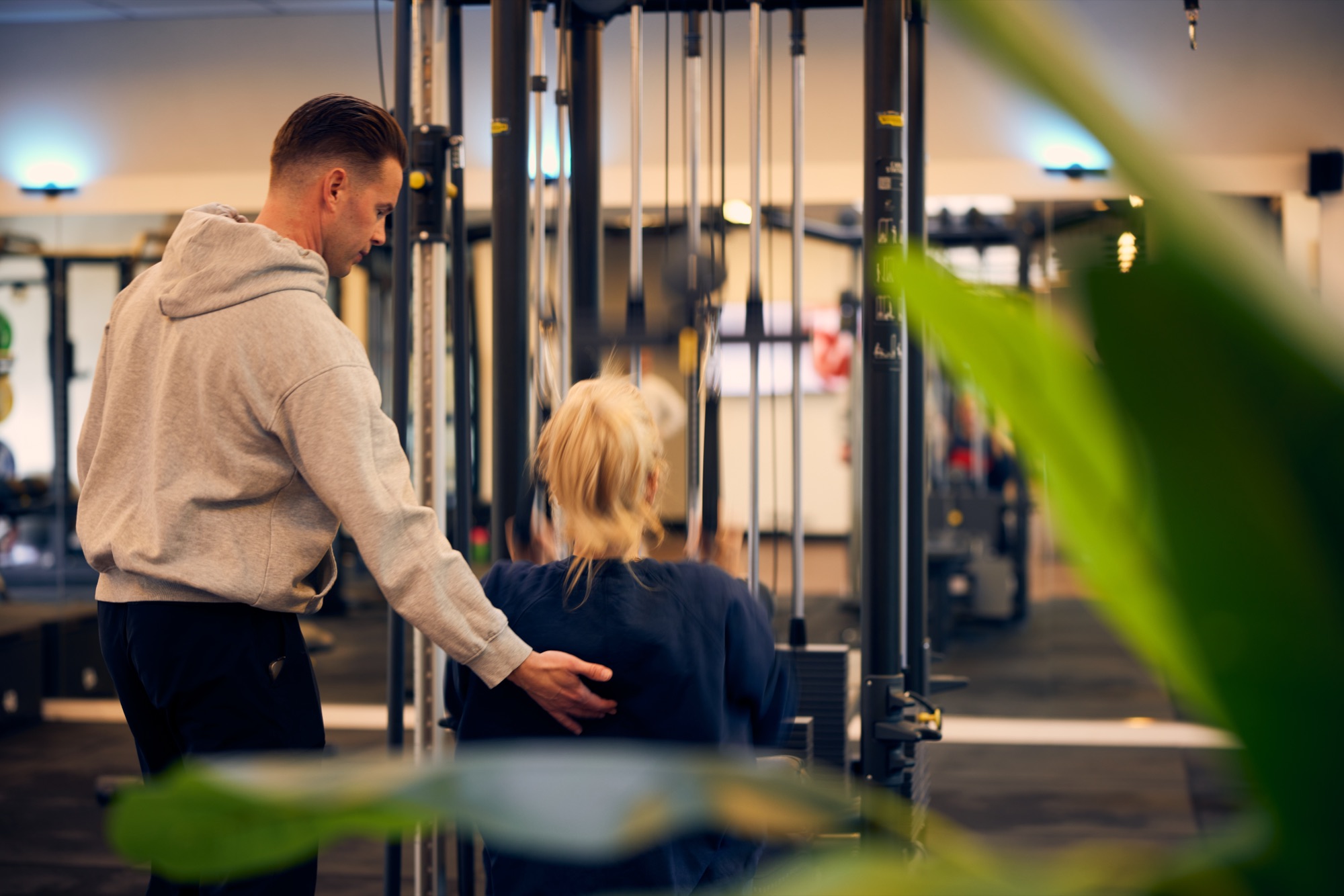 Personal trainer van L'Humain begeleidt een cliënt tijdens krachttraining