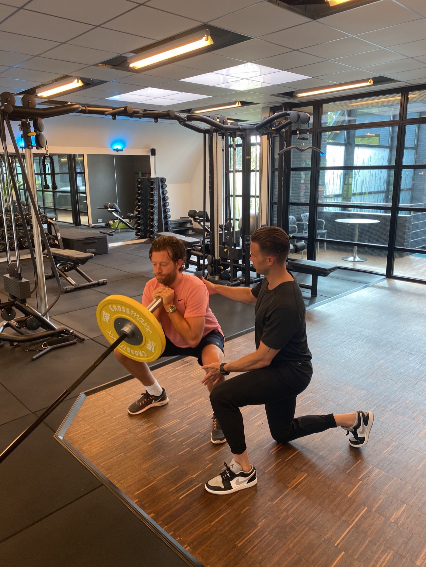 Personal trainer van L'Humain begeleidt een cliënt tijdens de training